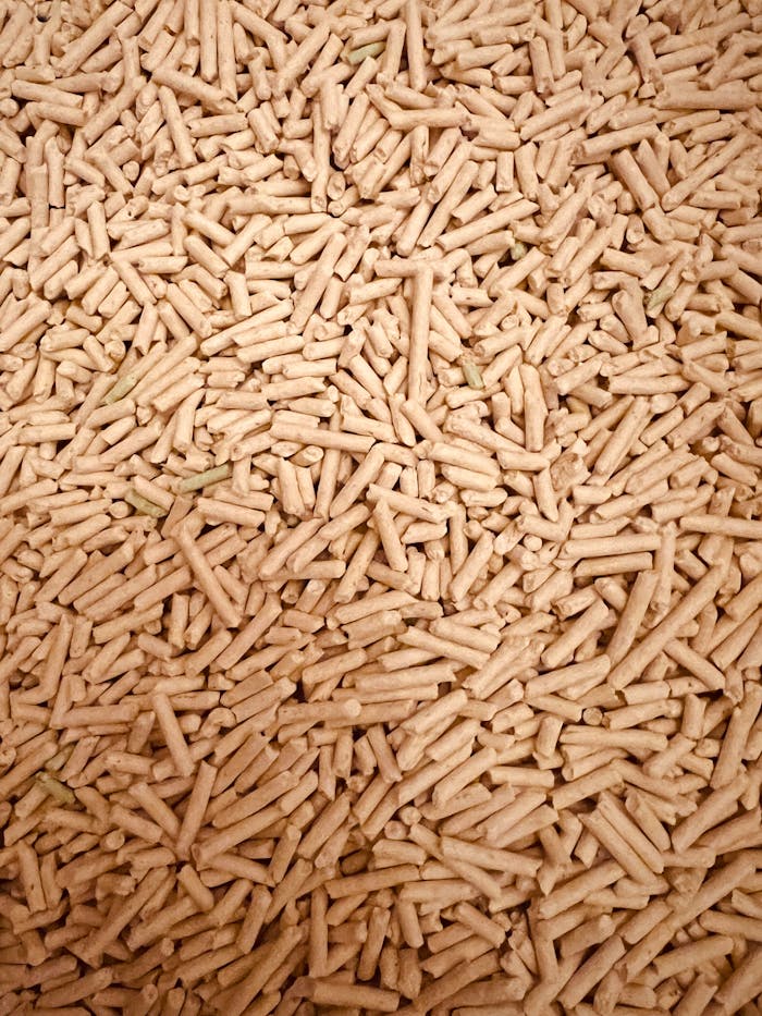 our-services-02 A detailed top view of a large pile of wood pellets used for renewable fuel and energy.